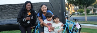 two women and two children standing next to bikes
